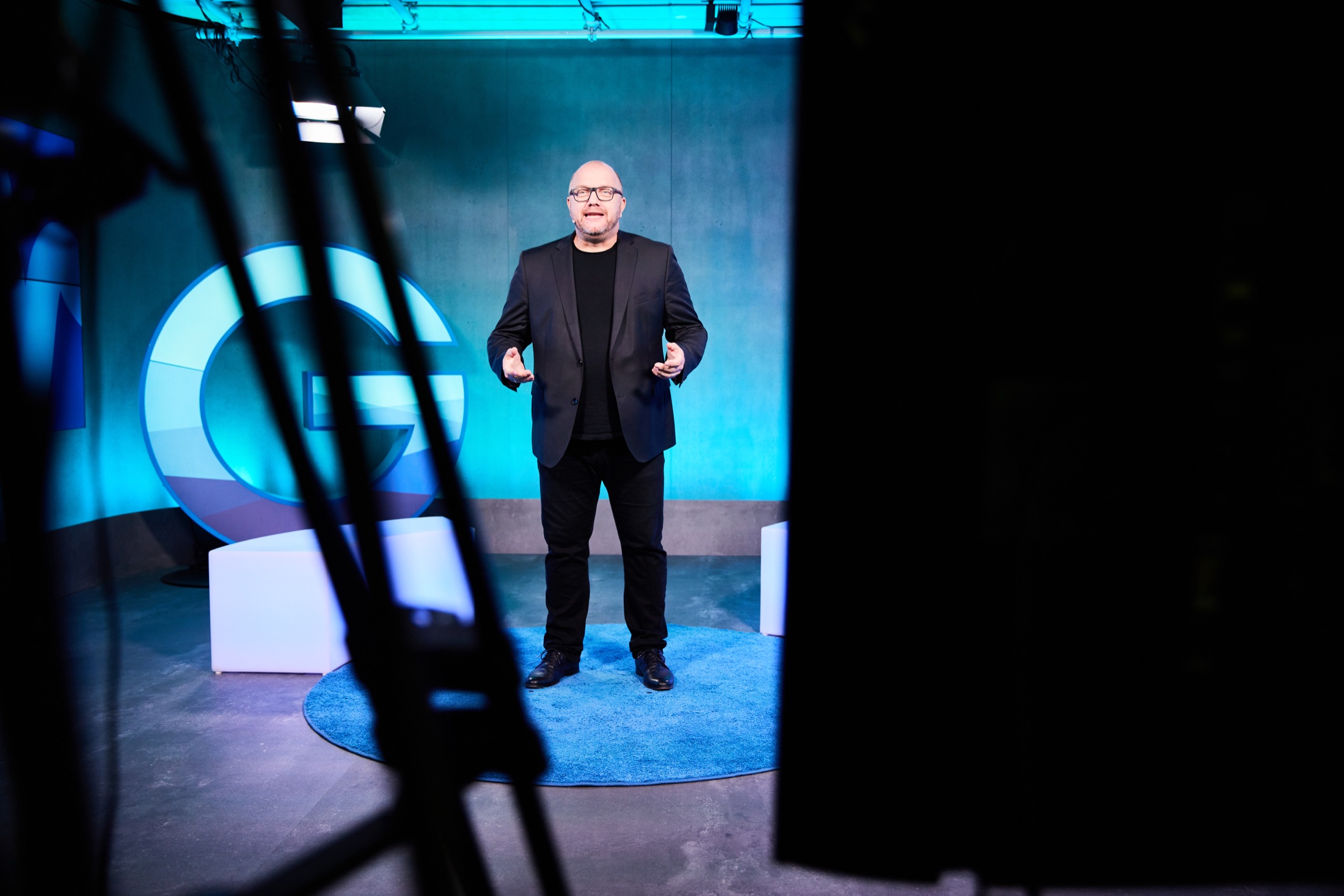 Michael Ehlers auf einer blau beleuchteten Studiobühne