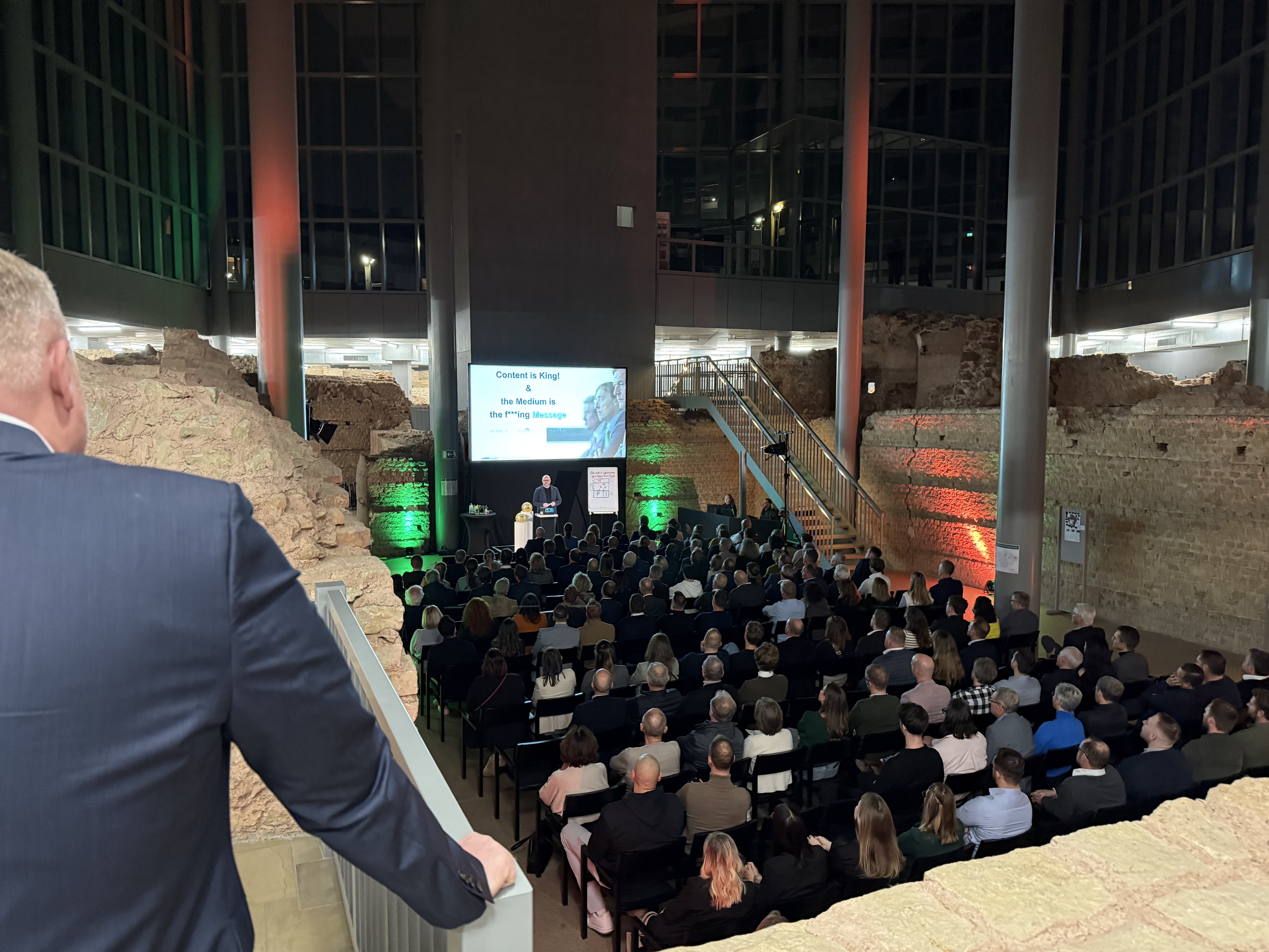 Michael Ehlers spricht in einem historischen Saal vor großem Publikum über Medien und Kommunikation